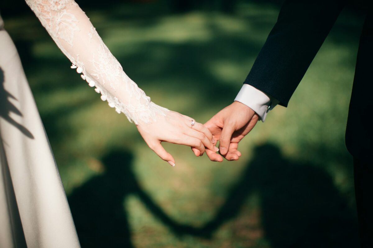 Tips for managing post wedding blues. A newly married couple holding hands